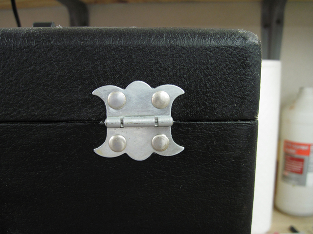 A close-up of the rear hinge after restoration. The finish is shiny and uniform.