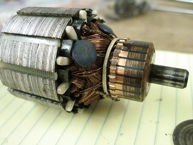A closeup of the commutator of the Alphasew motor. There is considerable carbon on the contacts and the rotor shaft demonstrates an uneven surface.